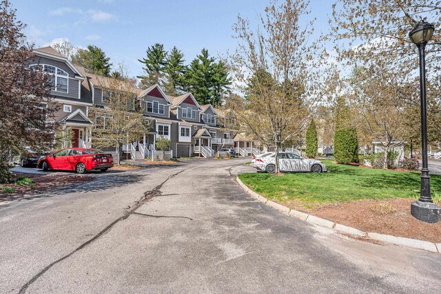 view of street featuring a residential view, street lighting, and curbs