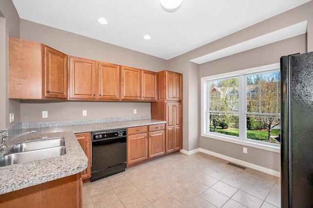 kitchen with a sink, baseboards, light tile patterned floors, visible vents, and black appliances