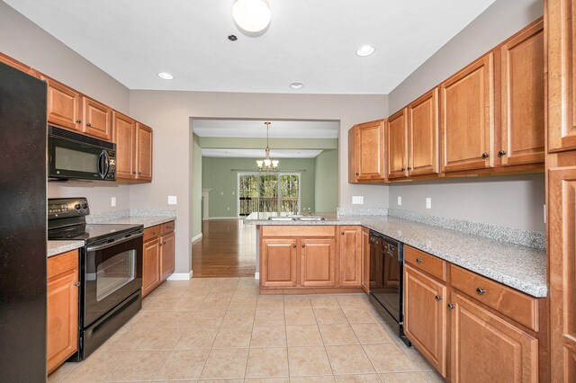 kitchen featuring a sink, a notable chandelier, brown cabinets, and black appliances
