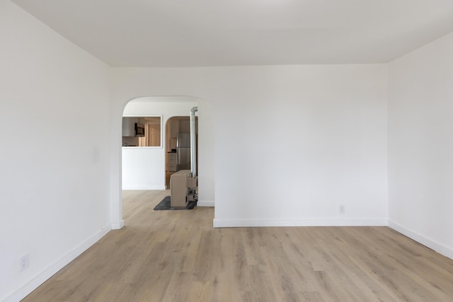 129 Temple St, Rutland City, VT 05701 - empty room with baseboards, arched walkways, and light wood finished floors