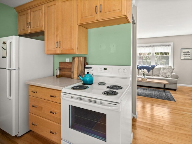 kitchen with light countertops, white appliances, and wood finished floors