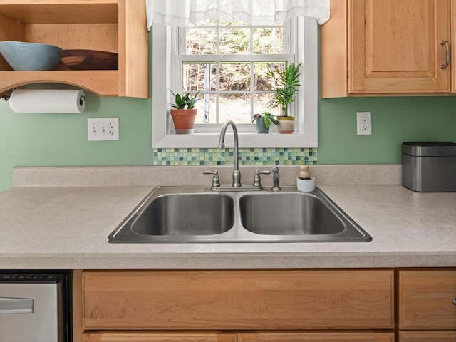 kitchen with a sink, dishwasher, and light countertops