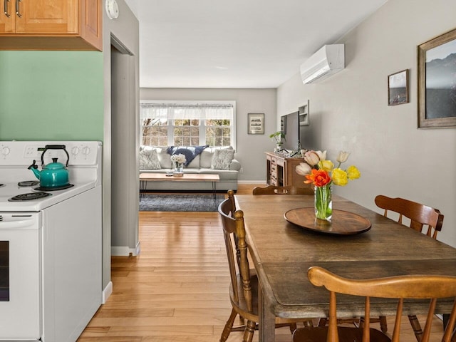 dining area with baseboards, a wall mounted air conditioner, and light wood-style flooring