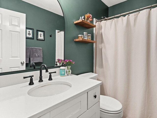 bathroom featuring toilet, curtained shower, and vanity