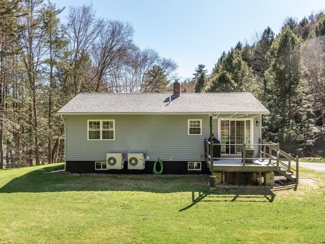 rear view of property with a lawn, a deck, ac unit, and a chimney