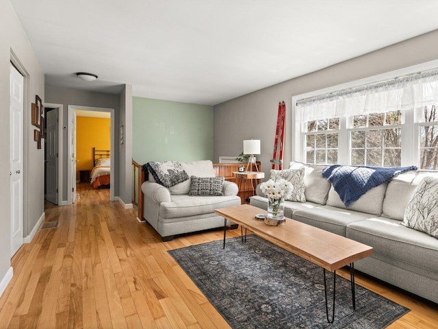 living room with baseboards and light wood finished floors
