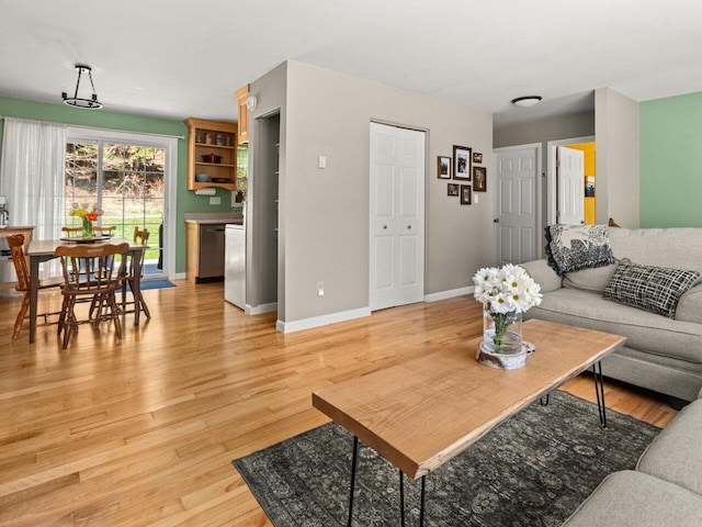 living area with baseboards and light wood-type flooring