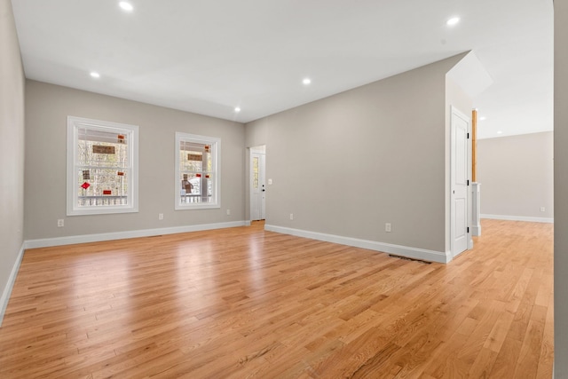 unfurnished living room with recessed lighting, baseboards, and light wood-type flooring