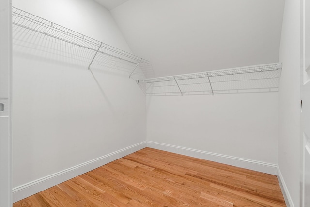 spacious closet featuring light wood-type flooring and lofted ceiling