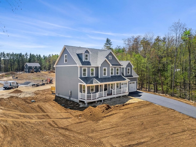 view of front of home with a garage, a porch, and driveway