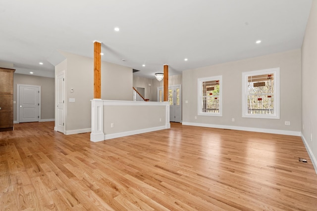 unfurnished living room featuring recessed lighting, plenty of natural light, and light wood-type flooring