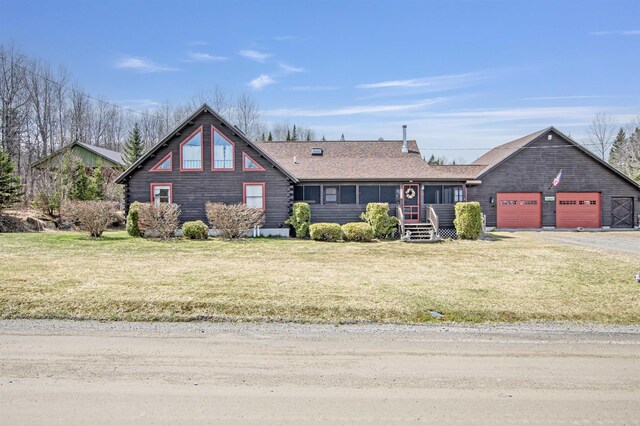 view of front of house featuring an attached garage, a front lawn, roof with shingles, and driveway