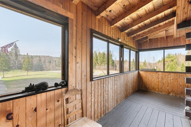 unfurnished sunroom featuring beam ceiling
