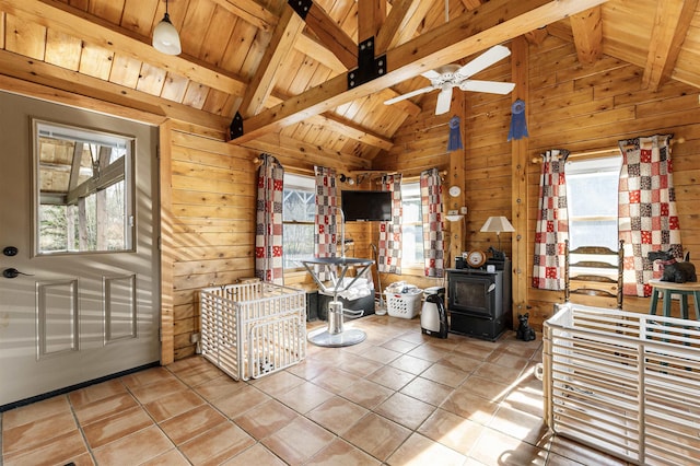living area featuring vaulted ceiling with beams, wood walls, and a wealth of natural light