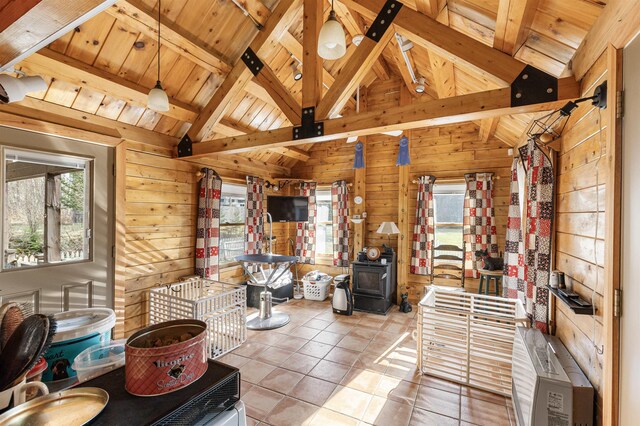 interior space featuring wood walls, lofted ceiling with beams, and a wealth of natural light