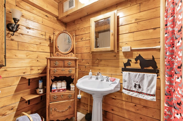 bathroom with visible vents and wood walls