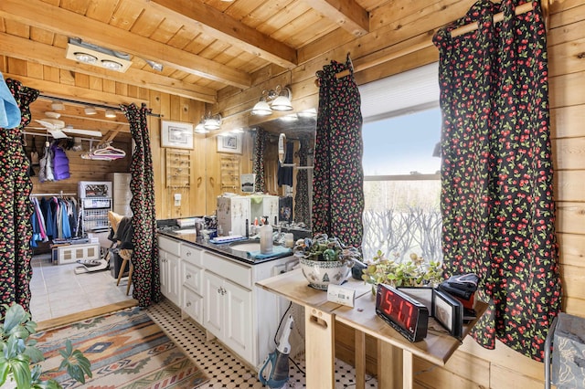 bathroom featuring tile patterned flooring, beam ceiling, wooden walls, and wooden ceiling