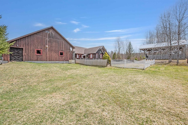 view of yard featuring a barn, fence, and an outdoor structure