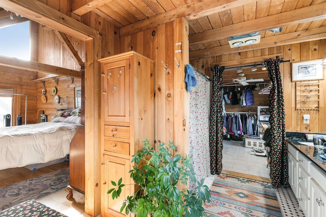 bathroom featuring a sink, wood ceiling, beamed ceiling, and wood walls