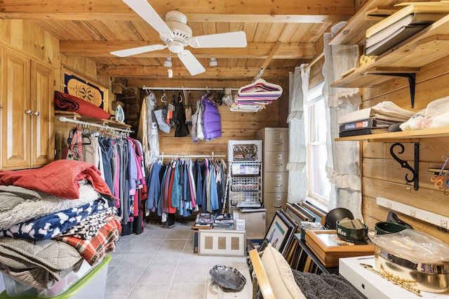 spacious closet featuring ceiling fan, light tile patterned floors, and beam ceiling