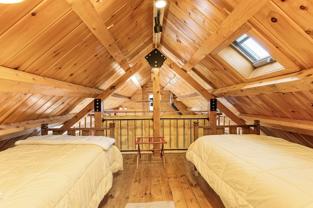 bedroom featuring wooden walls, lofted ceiling with skylight, hardwood / wood-style floors, and wooden ceiling