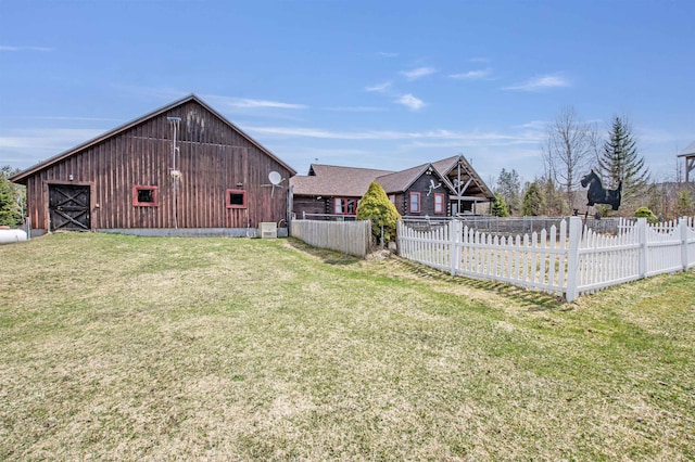view of yard with an outdoor structure, a barn, and fence