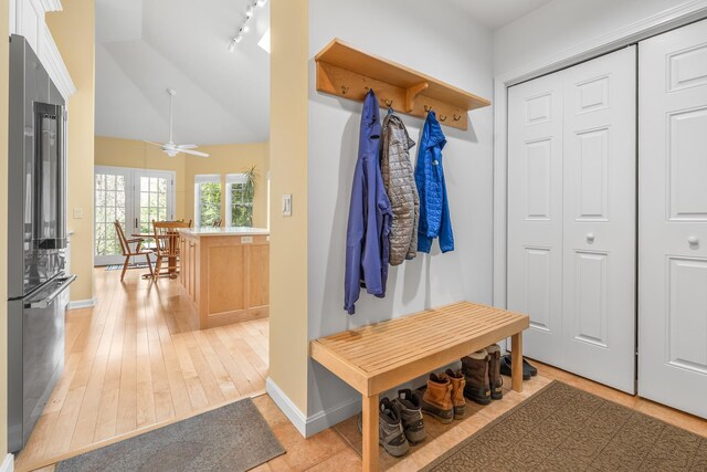 mudroom featuring baseboards, light wood-style floors, lofted ceiling, and track lighting