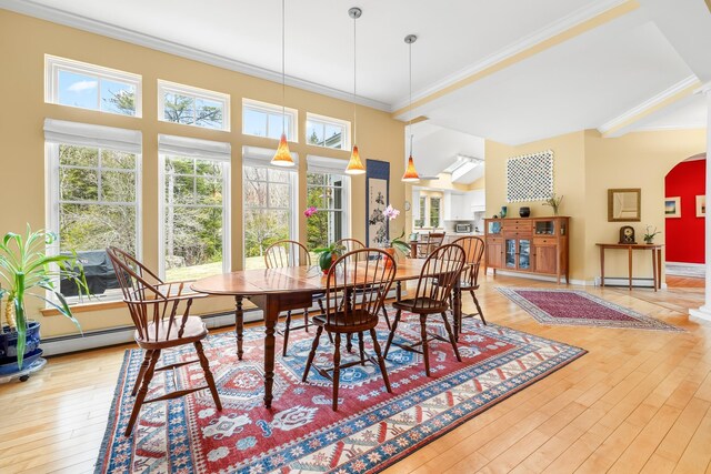 dining space featuring ornamental molding, arched walkways, a baseboard heating unit, and hardwood / wood-style floors