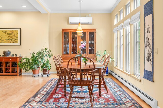 dining room with baseboard heating, light wood-style flooring, baseboards, a wall mounted AC, and ornamental molding