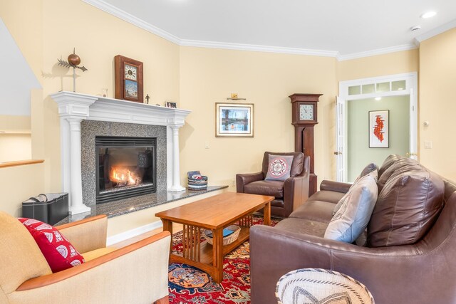 living area with crown molding, a glass covered fireplace, and wood finished floors