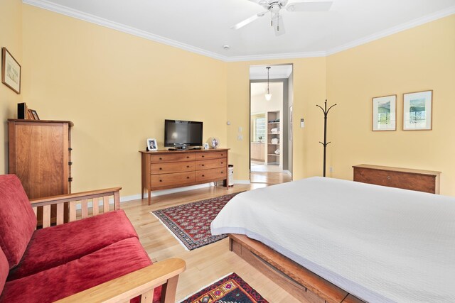 bedroom featuring crown molding, baseboards, ceiling fan, and light wood-style floors