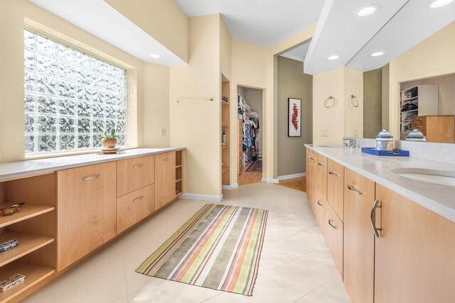 bathroom with recessed lighting, baseboards, a spacious closet, and vanity