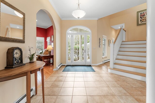 tiled foyer entrance featuring crown molding, a baseboard radiator, arched walkways, and stairway