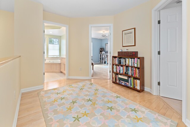 hallway with baseboards and light wood-style flooring