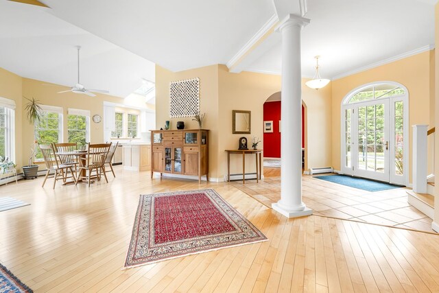 entrance foyer featuring arched walkways, ceiling fan, decorative columns, and hardwood / wood-style flooring