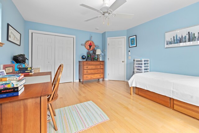 bedroom with ceiling fan, wood finished floors, and a closet