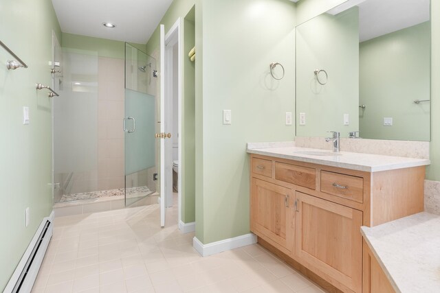 full bath with vanity, toilet, a baseboard heating unit, tile patterned floors, and a stall shower