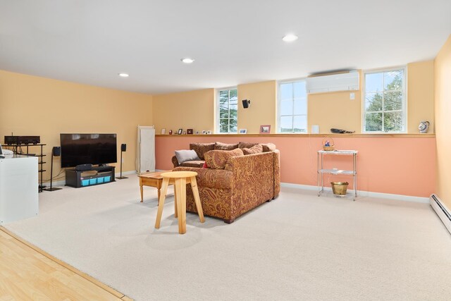 living room featuring an AC wall unit, carpet flooring, baseboards, and a healthy amount of sunlight