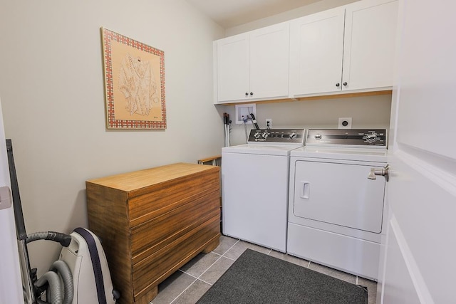 clothes washing area featuring independent washer and dryer, light tile patterned floors, and cabinet space