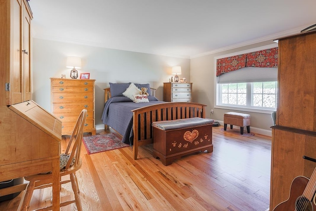 bedroom featuring crown molding, baseboards, and light wood finished floors
