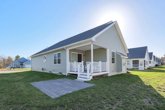 back of house featuring a lawn, a patio area, and covered porch