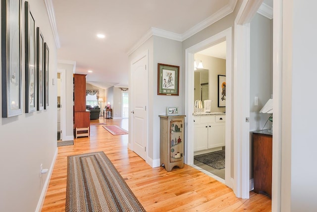 hall featuring crown molding, recessed lighting, light wood-style flooring, and baseboards