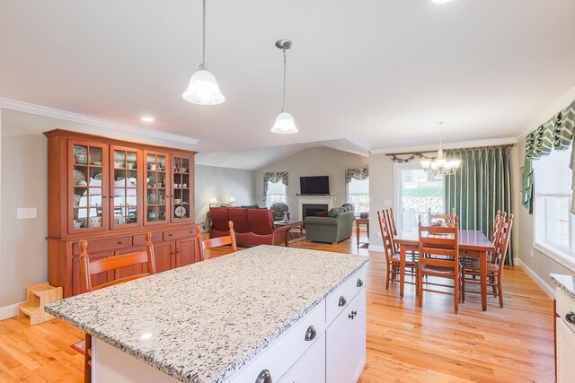 kitchen featuring plenty of natural light, light wood finished floors, and light stone countertops