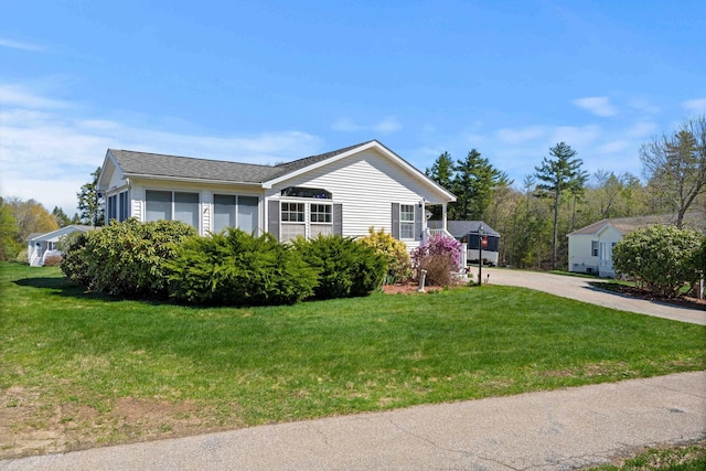 view of side of home featuring a lawn and driveway