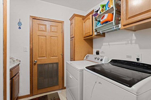 laundry area with washing machine and clothes dryer, visible vents, and cabinet space