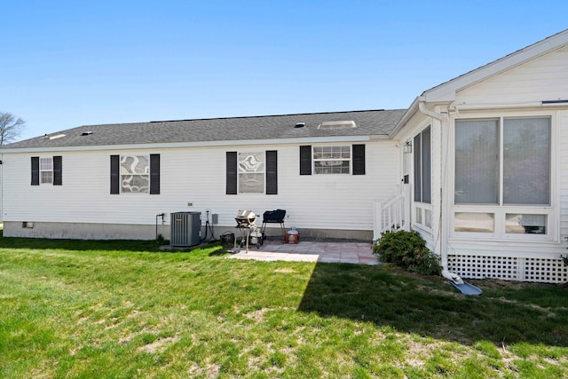 back of property featuring central AC unit, a patio area, and a yard