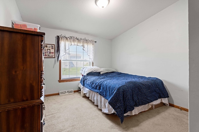carpeted bedroom featuring baseboards, visible vents, and vaulted ceiling