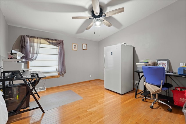 office area with a ceiling fan, visible vents, vaulted ceiling, baseboards, and light wood-style floors