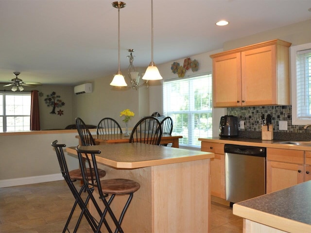 kitchen featuring a breakfast bar area, light brown cabinetry, tasteful backsplash, stainless steel dishwasher, and a wall mounted AC