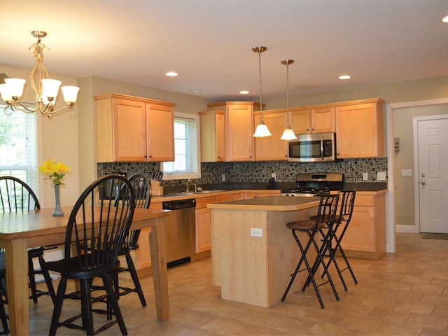 kitchen with light brown cabinets, a chandelier, stainless steel appliances, backsplash, and a kitchen island
